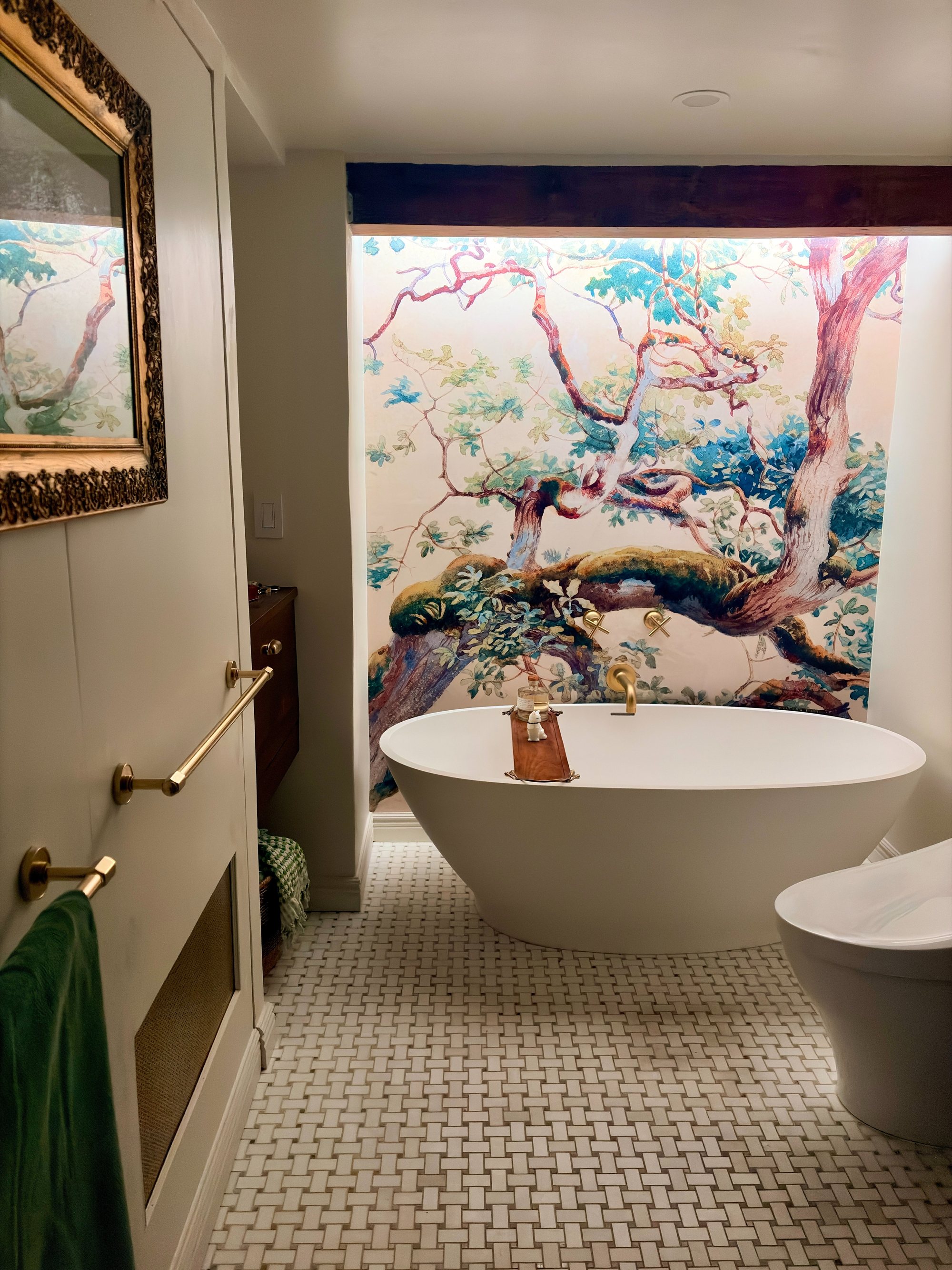 Bathroom with a hand-painted mural, freestanding tub, and brass fixtures